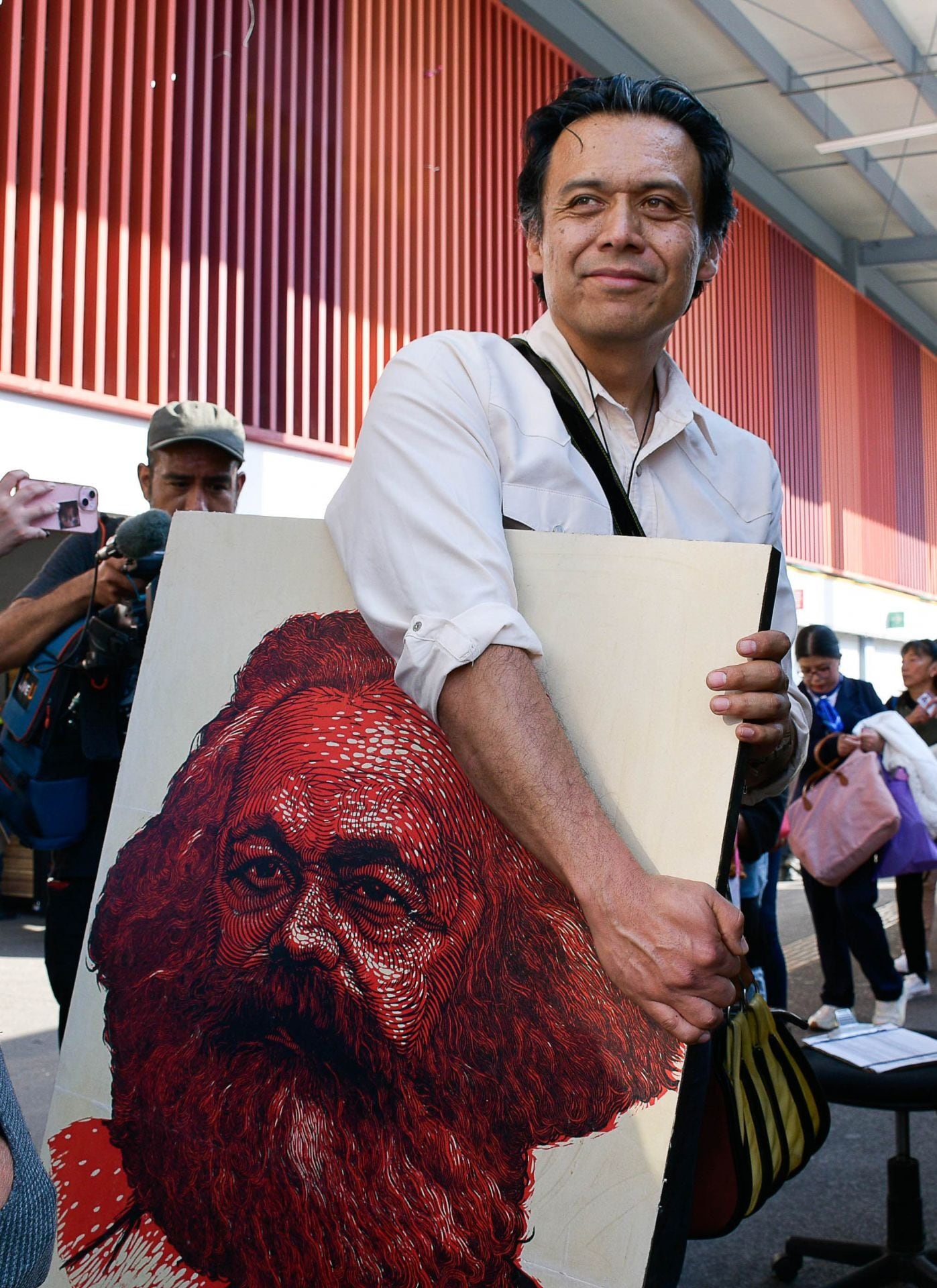 Marx Arriaga sale de su trichera en la SEP con su cuadro de Karl Marx.